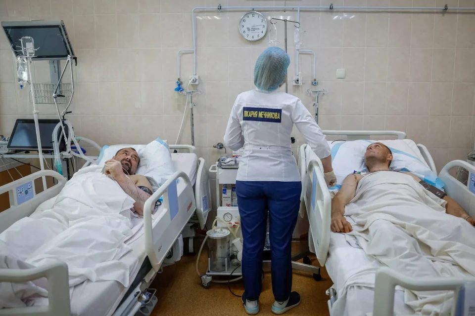 Медична сестра відвідує поранених воїнів у палаті лікарні