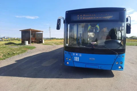 Синій тролейбус 189 біля дерев’яної зупинки на ґрунтовій дорозі